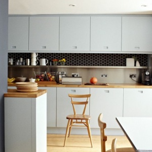 Ciemna przestrzeń nadblatowa w jasnej kuchni z płytką ceramiczną heksagonalną. Fot. Raw Decor
