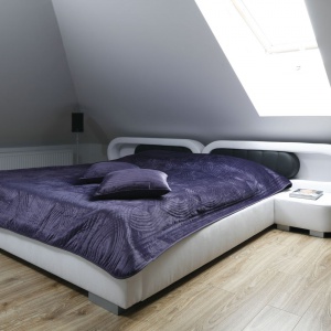 Nieco kosmiczne, futurystyczne łóżko małżeńskie stoi na klasycznej, drewnianej podłodze. Projekt: Marta Kilan. Fot. Bartosz Jarosz