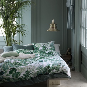 Komplet tekstyliów dekoracyjnych idealny zarówno do wnętrz, jak i na taras lub balkon. Utrzymany w kolorach zieleni i szarości. Fot. Broste Copenhagen