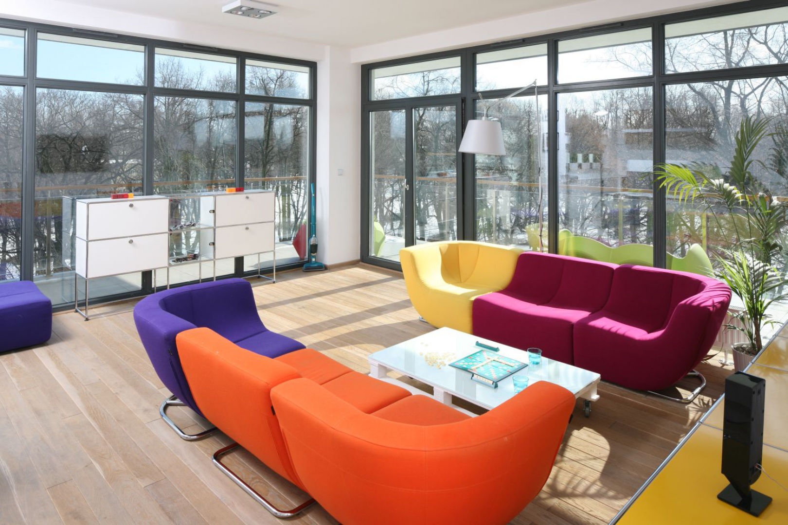 Nowoczesny salon jest pełen światła za sprawą dwóch sąsiadujących ścian, które są niemal w całości przeszklone. Projekt: Konrad Grodziński. Fot. Bartosz Jarosz