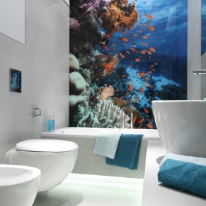 Skąpana w bieli łazienka zyskuje kolor za sprawą fototapety z barwnym podwodnym światem. Projekt: Anna Maria-Sokołowska. Fot. Bartosz Jarosz