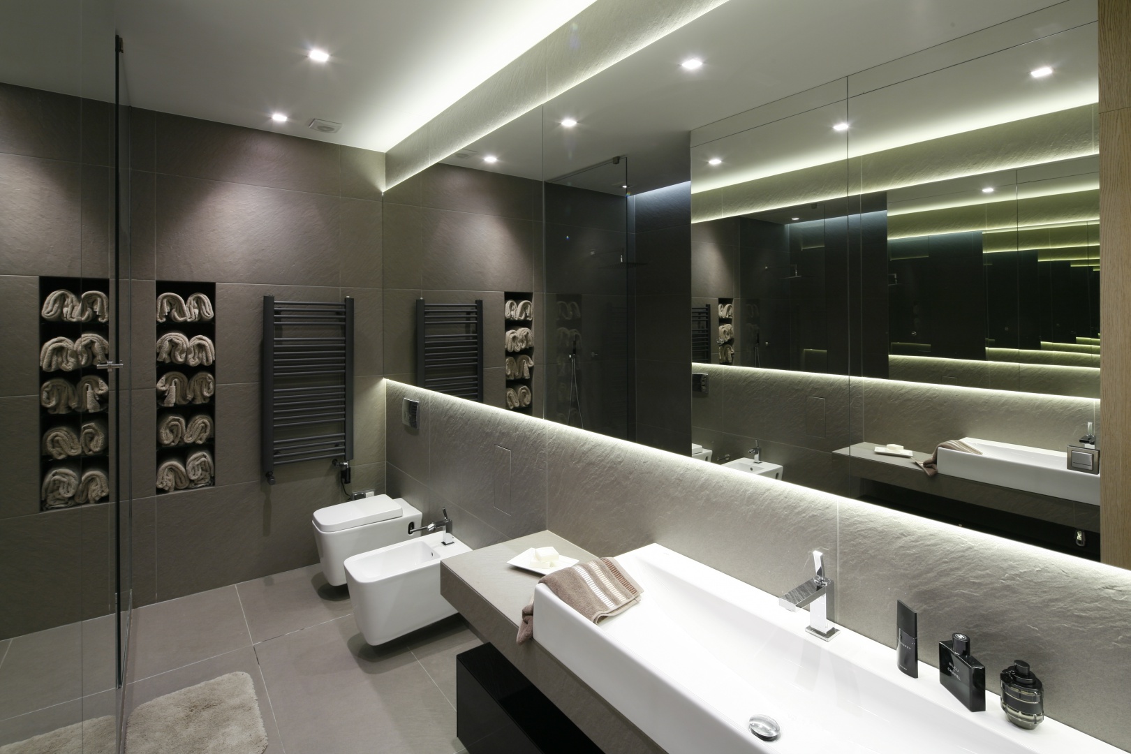 W minimalistycznej, szarej łazience duza role odgrywa światło, a także duże lustrzane powierzchnie. Projekt: Małgorzata Muc, Joanna Scott. Fot. Bartosz Jarosz