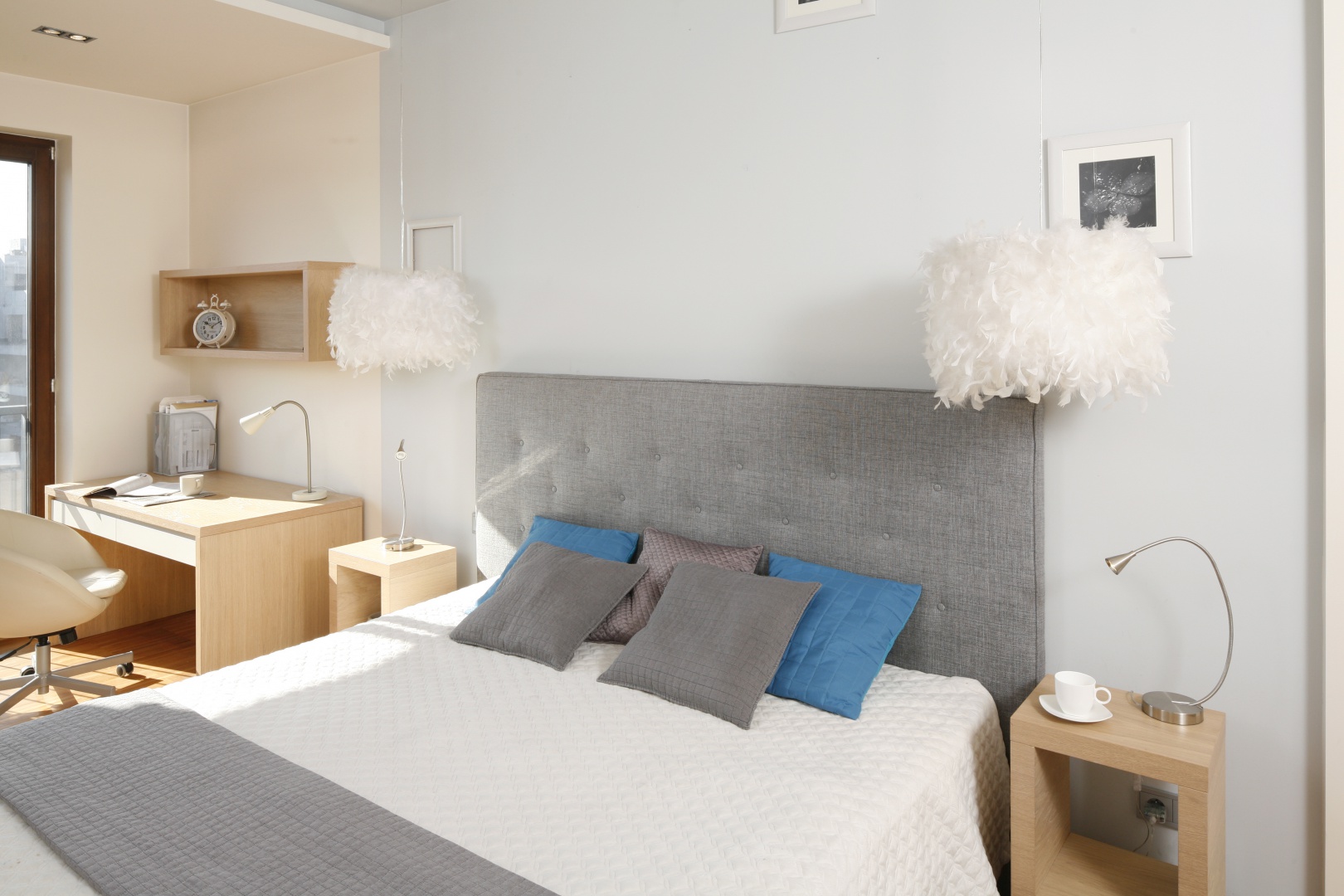 Sypialnię w bieli i szarościach ociepla dodatek drewna aranżacji, czyniąc wnętrze przytulnym. Projekt: Marta Kruk. Fot. Bartosz Jarosz 