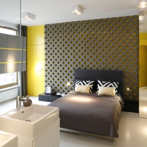 W centrum sypialni umieszczono duże, wygodne łóżko z nakryciem kolorystycznie łączącym się z kolorystyką ścian. Proj wnętrza Monika i Adam Bronikowscy, Hola Design. Fot. Bartosz Jarosz.