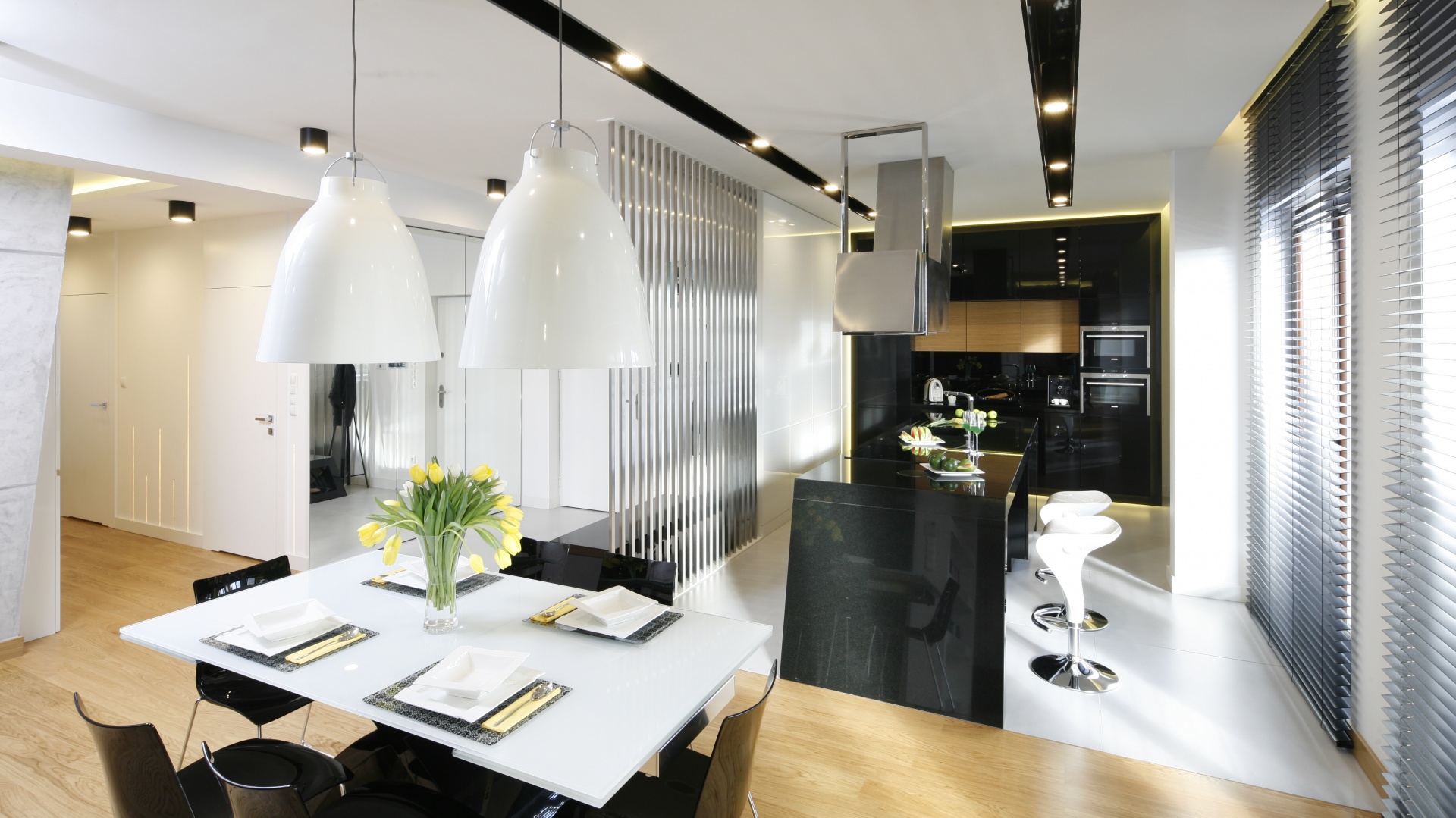 Nowoczesną zabudowę kuchenną uzupełnia oryginalna wyspa zaprojektowana specjalnie do tego wnętrza. Kubistyczna forma okapu to także autorski projekt zespołu Hola Design. Fot. Bartosz Jarosz