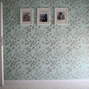 Pojedyncze ściany zostały uwydatnione poprzez zastosowanie wzorzystych tapet w delikatnych odcieniach zieleni. Projekt i zdjęcia: Marcin Herman, Premiere Design