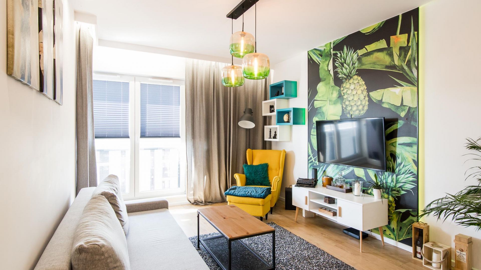 We wnętrzu dominuje biel i czerń, ale widoczny jest kolorowy akcent jak np. żółty fotel w salonie, czy zielone lampy nad stołem w kuchni.Projekt: The Space. Fot. Piotr Czaja