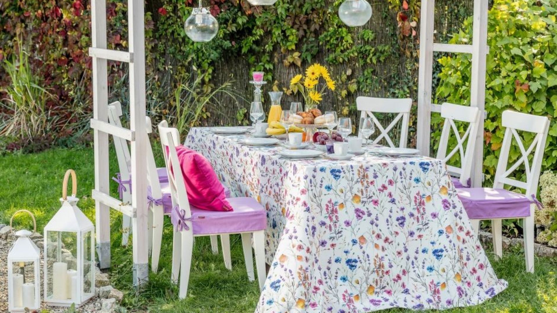 Obrus prostokątny z kolekcji tkanin Flowers, poszewka Kinga na poduszkę z kolekcji Loneta. Fot. Dekoria.pl