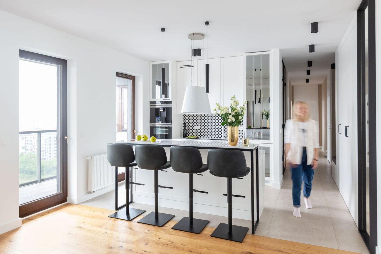 Kuchnia jest otwarta na salon. Umowną granicę z częścią wypoczynkową tworzy wyspa z barkiem. Projekt i zdjęcia: Decoroom