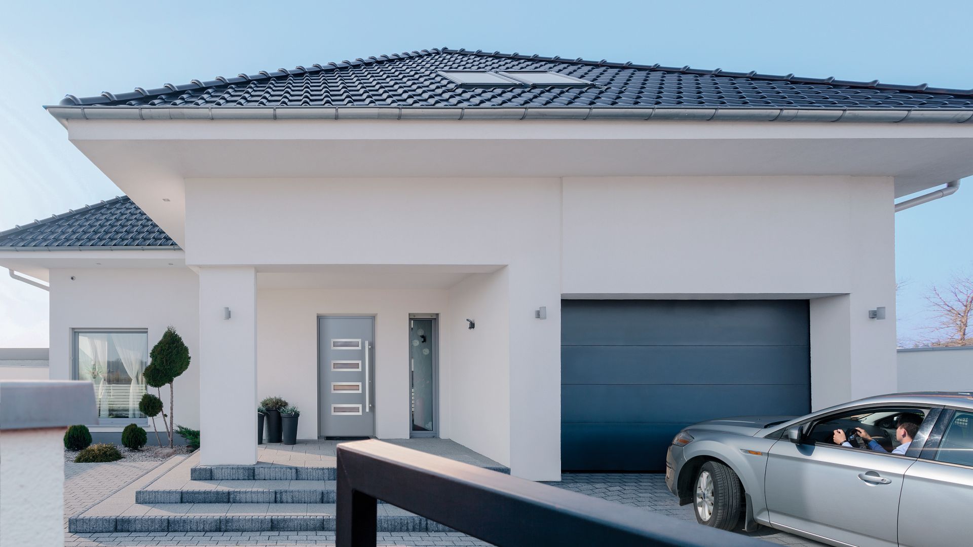 Brama UniTherm powstała w odpowiedzi na potrzeby budownictwa energooszczędnego. W pełni wykorzystuje właściwości cieplne panelu Innovo o grubości 60 mm oraz zastosowanych w niej systemów uszczelnień. To więcej zaoszczędzonej energii w domu, ponieważ straty ciepła zostały wyeliminowane w najbardziej newralgicznych miejscach skrzydła bramy. Fot. Wiśniowski