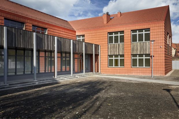Kreatywne podejście architektów odpowiedzialnych za projekt rozbudowy Szkoły Podstawowej im. Jana Pawła II w Psarach na Dolnym Śląsku zaowocowało budynkiem, w którym dachówka ceramiczna pojawia się nie tylko jako wykończenie dachu, ale także