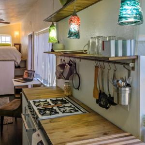 W środku Recyklingowego domu w Idaho znalazło się miejsce na osobną łazienkę z dużym prysznicem, w pełni funkcjonalną kuchnię, rozmiarami dorównującą niejednej urządzonej w kawalerce czy mniejszym mieszkaniu, a także salon z łóżkiem na podwyższeniu, w którym mieszczą się półki i szafy. Fot. minimotives.com