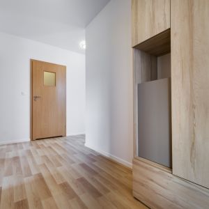 Białe ściany, drewniana podłoga, drewniane futryny i drzwi wewnętrzne - klasyczny przykład stylu skandynawskiego. Fot. Shutterstock