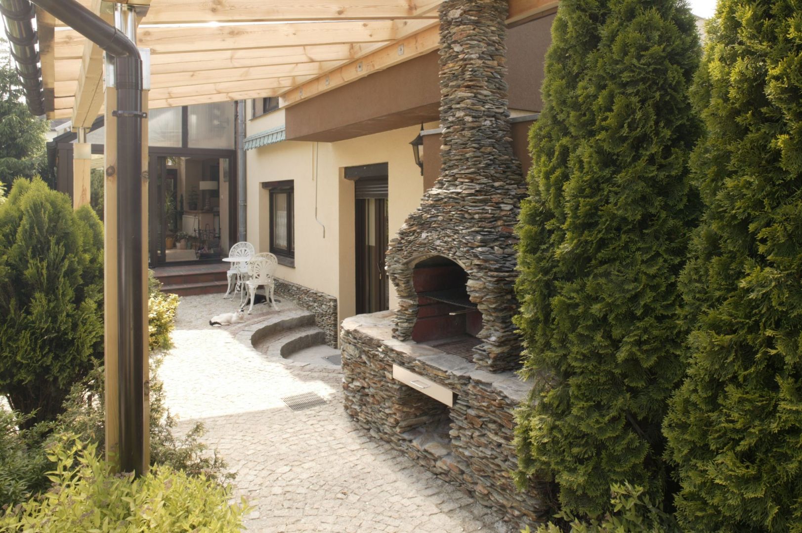 Głównym elementem części kulinarnej otoczenia domu jest wykonany z kamienia grill, który pełni również funkcję przydomowej wędzarni. Fot. Monika Filipiuk-Obałek