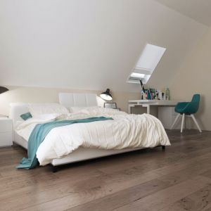 Naturalny odcień dębowej podłogi ociepla dość ascetycznie urządzoną sypialnię na poddaszu. Projekt: Z92, Z500.