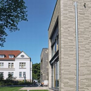 Pomysł powstania domu zrodził się z chęci wprowadzenia nowej budowli w dialog ze starym budynkiem „Domu Anny“, dlatego w projekcie zdecydowano się na cegłę klinkierową Röben Faro o cieniowanej szarej kolorystyce i podłużnym formacie. Fot. Röben