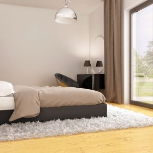W tej sypialni główną rolę gra duże łoże z tapicerowanym zagłowiem. Wnętrze ocieplają miękkie tkaniny. Projekt Zx100, Fot. Z500
