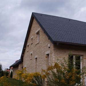 Łupek kamienny na dachu i dolomit na elewacji zastosowano w domu w Strzeniówce. Przepięknie prezentuje się w sielskim otoczeniu. Fot. S&O Projekty Sylwii Strzeleckiej