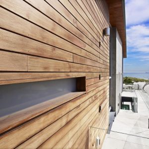 Drewno, jako materiał naturalny idealnie nadaje się na elewację domu zlokalizowanego na plaży, nad oceanem. Fot. West Chin Architects
