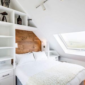 W pięknej białej sypialni ciekawie prezentują się ciemne drewniane elementy, nawiązujące do tradycji budynku. Fot. Evolution Design