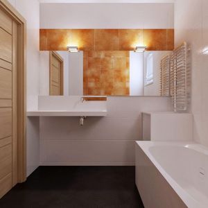 Również w białej łazience można znaleźć pomarańczowe kafelki i grafitową podłogę. To elementy łączące wszystkie pomieszczenia domu. Fot. Z500