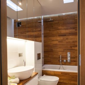Motywem przewodnim w łazience są lustra oraz eleganckie i ciepłe drewno teakowe. Fot. Adam Ościłowski