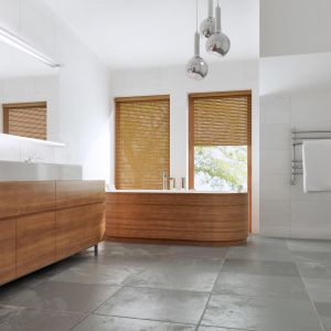 Przestronne wnętrza łazienki ocieplają drewniane elementy wykończenia. Dodatkową zaletą są duże okna, przez które wpada światło naturalne. Projekt: ZB5. Fot. Z500