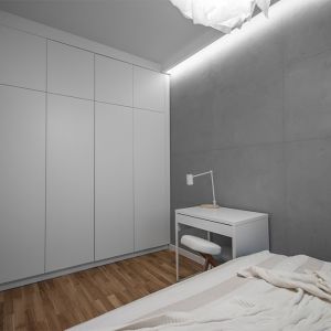 Całe wyposażenie sypialni stanowi biała, wykonana na zamówienie zabudowa: łóżko, toaletka oraz stoliczki pod lampki. Betonowy tynk na ścianach podkreślił nowoczesny nastrój wnętrza. Fot. Progetti Architektura