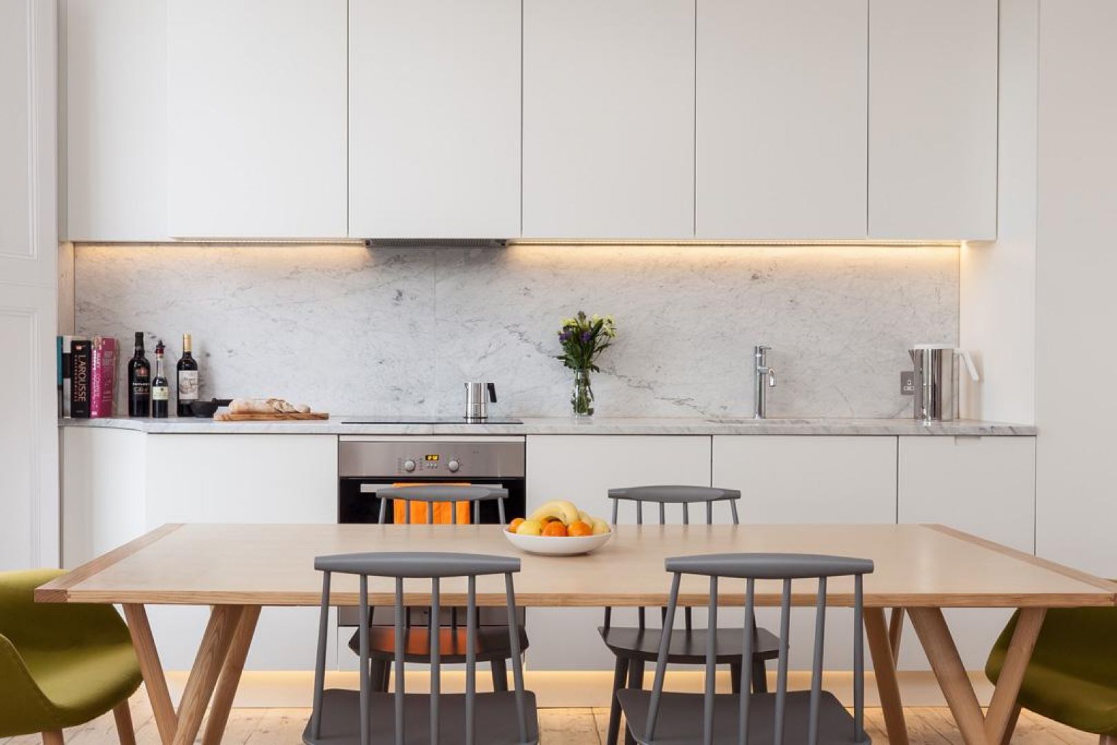 W kuchni zdecydowano się na proste, białe meble. Dzięki temu wnętrze nabiera nowoczesnego, minimalistycznego charakteru. Fot. Architecture for London 