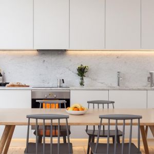 W kuchni zdecydowano się na proste, białe meble. Dzięki temu wnętrze nabiera nowoczesnego, minimalistycznego charakteru. Fot. Architecture for London 
