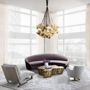 Jasny, biały salon z fioletową sofą Vamp, nadajacą wraz ze stołem i złotym żyrandowlem luksusowego charakteru całemu pomieszczeniu. Fot. Boca do Lobo