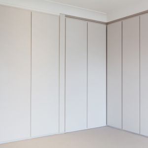 Praktyczne szafy są niemal niezauważalne i nie burzą minimalistycznej aranżacji wnętrza. Fot. Nick Leith-Smith