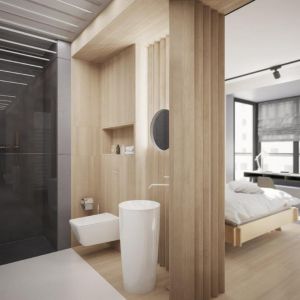 Na uwagę zasługuje również łazienka gościnna z wanną, która jest cała biała. Jej głównym elementem jest podkreślona umywalka, której bryła jest spójna z całym mieszkaniem. Została otoczona drewnem, a wnęki wypełnia szarość. Fot. 81.WAW.PL