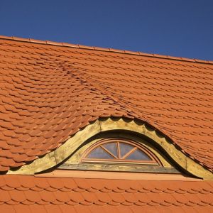 Tradycyjna dachówka karpiówka sprawdza się na dachach nowo powstających domach jednorodzinnych. Sposób montowania i niewielkie rozmiary pojedynczej dachówki umożliwiają wykonanie skomplikowanych elementów dachu, jak fale, wieżyczki, wole oka. Fot. Wienerberger 