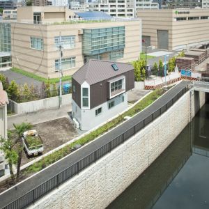 Gęsta zabudowa, rzeka i droga biegnąca tuż obok to tło, na którym dom zaprojektowany przez architekta Kota Mizuishi zdecydowanie się wyróżnia. Fot. Hiroshi Tanigawa