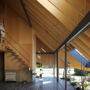Architekt zastosował proste stalowe ramy jako konstrukcję okalającą kuchnie i podtrzymującą skośny dach, na której zostały zamontowane przesuwające się przeszklone drzwi. Fot. Kai Nakamura