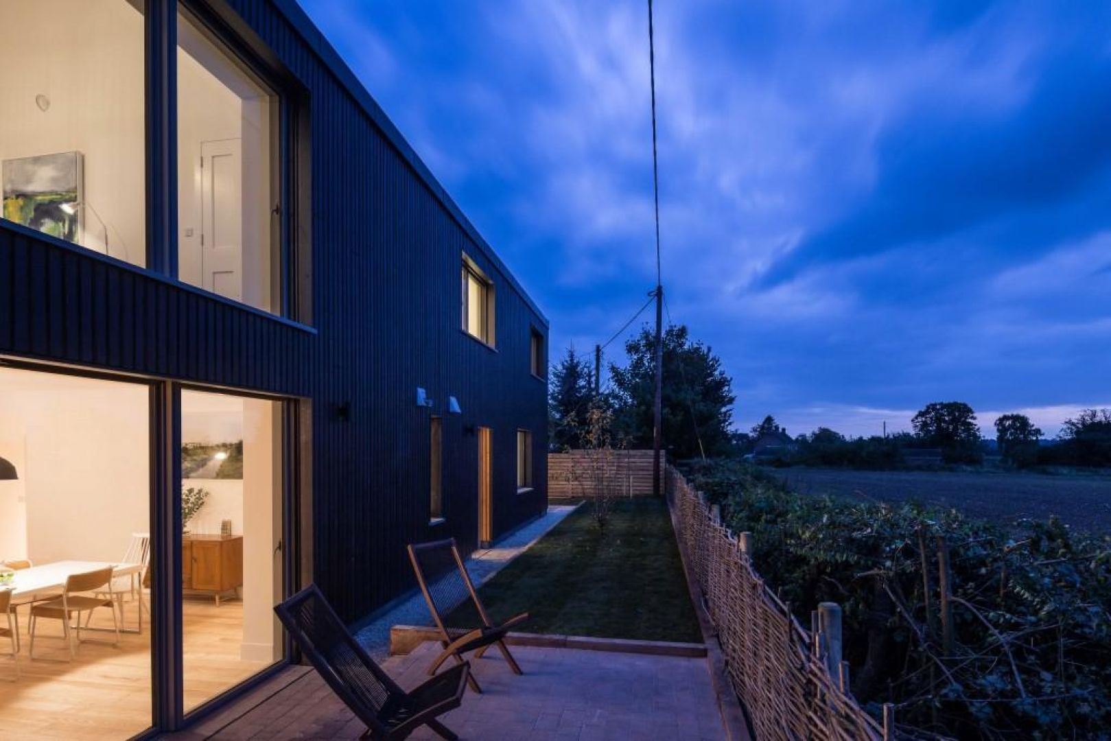 Proste ogrodzenie i niewielki taras umożliwiają miłe spędzanie czasu w ciepłe wieczory. Fot. Gresford Architects