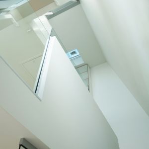 Dalej stalowe schody wiodą użytkowników na wyższe kondygnacje przez otwarte atrium, gdzie znalazła się przestrzeń dla sypialni, gabinetu oraz łazienki. Fot. Thom Craig Architects 