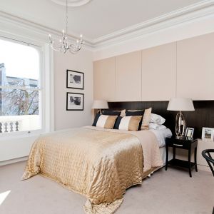 Sercem pięknej, jasnej sypialni jest łóżko, któremu elegancji dodaje złota narzuta. Fot. Nick Leith-Smith