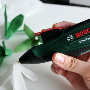 Przy pomocy akumulatorowego pistoletu do klejenia Bosch GluePen łączymy kilka warstw płatków, tworząc wielobarwne kwiaty. Fot. Bosch