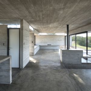 W domu dominuje wypolerowany beton, szykowne szkło oraz aluminiowe ramy. Stoją one w opozycji z surowym betonem imitującym fakturę drewnianej deskęi. Fot. Daniela Mac Adden 