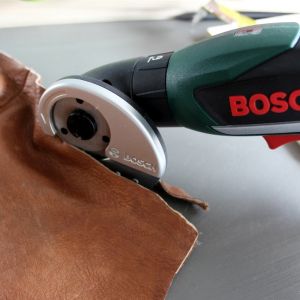 Przytnij skórę na uchwyty -  potrzebne będą dwa kawałki na uchwyty boczne, każdy ok. 13x3,5 cm. Z pomocą przyjdzie ci np. wkrętarka akumulatorowa Bosch IXO z adapterem do cięcia. Fot. Bosch