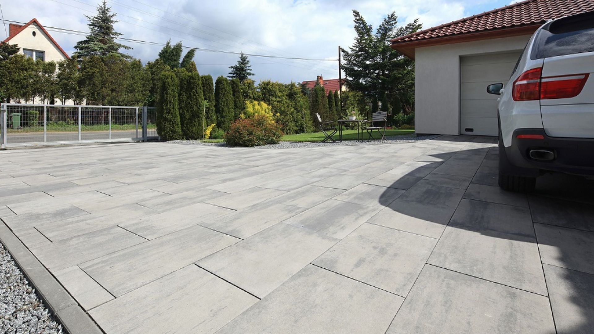 Minimalna szerokość podjazdu to 2,8-3 m, przy zachowaniu min. 5 m długości. Każde dodatkowe auto wymaga powiększenia tych minimalnych wymiarów. Tak duża przestrzeń, zaaranżowana z użyciem kostki brukowej, nie może ujść niczyjej uwadze. Fot. Polbruk