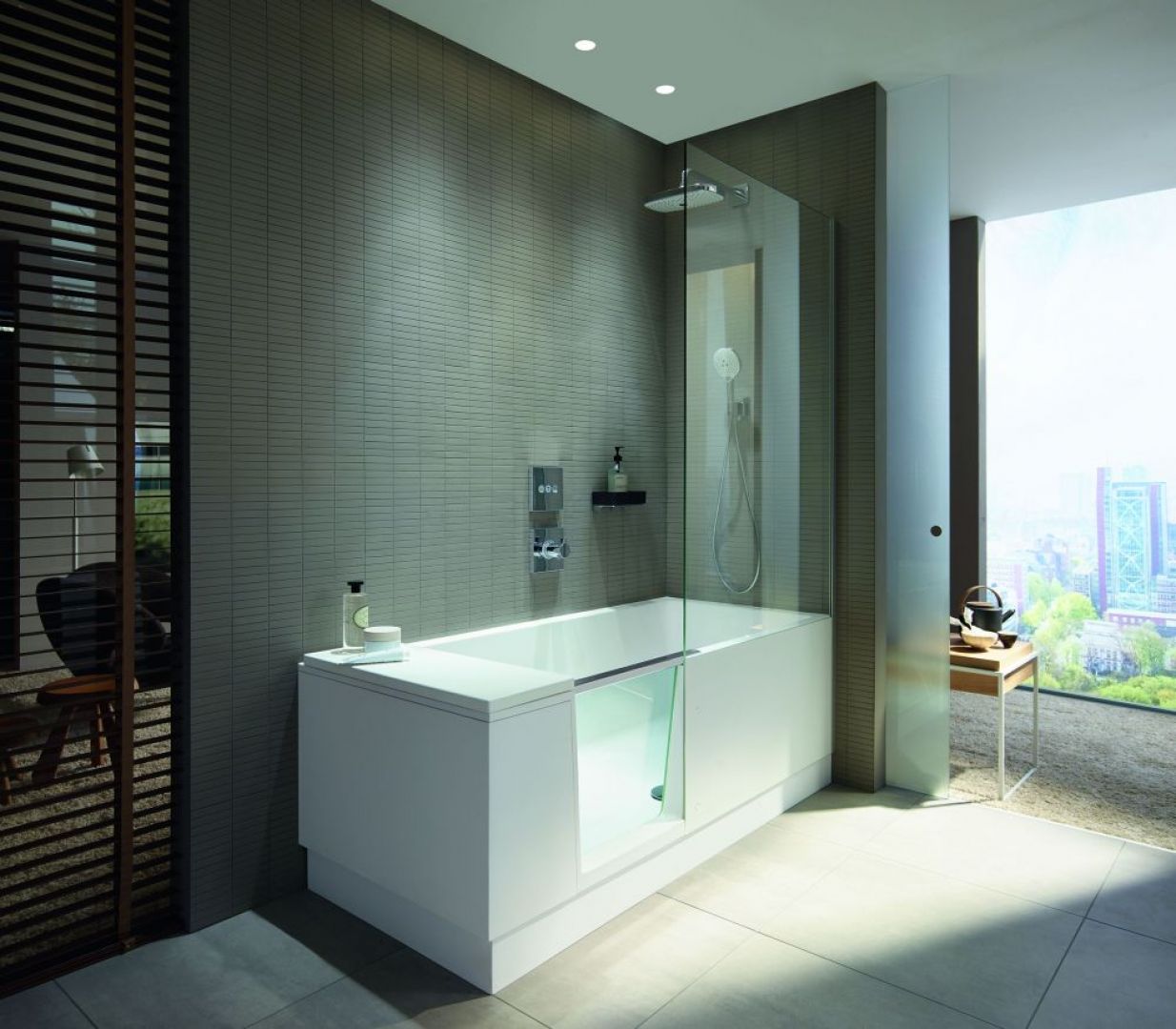 Shower&Bath projektu EOOS dla firmy Duravit, to połączenie prysznica typu walk–in z wanną. Zintegrowane szklane drzwi łatwo przekształcają wannę w dostępny, otwarty prysznic. Kiedy drzwi są otwarte do wewnątrz wanny, znikają pod wodoodpornym oparciem i pozostają niewidoczne. Fot. Duravit