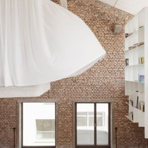 Zasłony i meble aranżują przestrzeń subtelnie oddzielając przestrzeń prywatną w tym otwartym, loftowym wnętrzuFot. Tobias Colz
