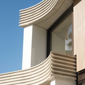 Architekt Luigi Rosselli zaprojektował górny, uliczny apartament na poziomie ulicy z zakrzywioną betonową fasadą, która nie tylko nadaje niepowtarzalny charakter elewacji, ale powstała z myślą powitania mieszkańców przy wejściu z przysłowiowymi „otwartymi ramionami”. Fot. Edward Birch and Prue Roscoe