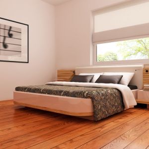 Przestronna sypialnia zyskuje na przytulności dzięki drewnianej podłodze i tapicerowanemu zagłówkowi. Uwagę przykuwają nowoczesne szafki nocne o ciekawej formie. Fot. Z500