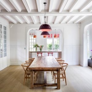 Jadalnia z dużym drewnianym stołem idealnie wpisuje się w wystrój całego domu. Fot. Adrià Goula Sardà