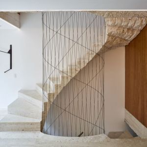 Konstrukcja wewnętrznych schodów wspornikowych wykonanych z trawertynu wznosi się z podłogi w piwnicy i wije spiralnie aż do świetlika w dachu. Fot. Amin Taha Architects 