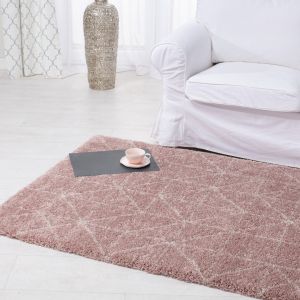 Pudrowo-różowy dywan w zestawieniu z białymi meblami sprawi, że pokój będzie wyglądał wyjątkowo przytulnie. Fot. Dekoria.pl